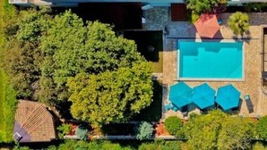 Eine Luftaufnahme eines Wohnhauses mit Swimmingpool, Sitzgelegenheiten im Freien und einem gepflegten Garten.
