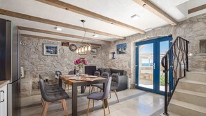 A dining area with a stone wall, a wooden ceiling, and a staircase with a metal railing. - NEW! Lovely Villa With Heated Pool and Sea View (Omis - Split Region)
