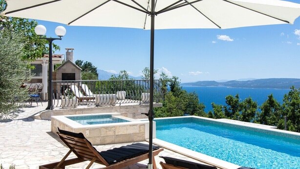 A pool area with lounge chairs and an umbrella, overlooking a scenic view of the sea and mountains. - NEW! Lovely Villa With Heated Pool and Sea View (Omis - Split Region)