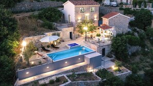 A villa with a swimming pool, outdoor seating, and a stone wall surrounding the property. - NEW! Lovely Villa With Heated Pool and Sea View (Omis - Split Region)
