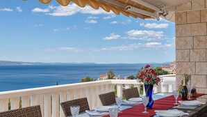 Une table dressée pour deux personnes, avec vue sur la mer.