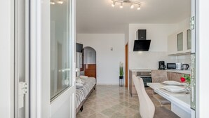 A modern, compact bedroom with a bed, bedside table, and a large window. - Apartment for 4 Persons With Pool (Stanici)