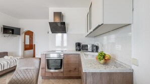 A compact kitchen with a built-in oven, microwave, and coffee maker. - Apartment for 4 Persons With Pool (Stanici)