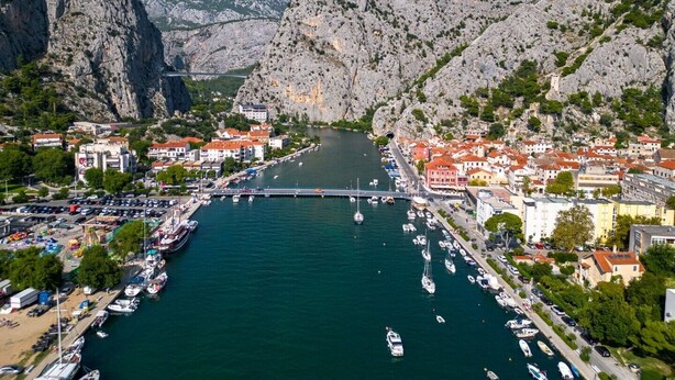 A coastal town with a marina, buildings with red roofs, and rocky mountains in the background. - Apartment for 4 Persons With Pool (Stanici)