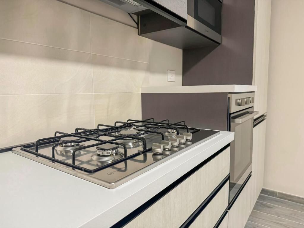 A kitchen with a white stove, a microwave, and a built-in oven.