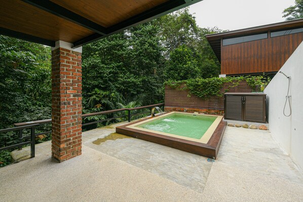 A modern outdoor pool area with a brick column, a wooden deck, and a metal railing. - The HIJAU Camp & Cabin (Ipoh)