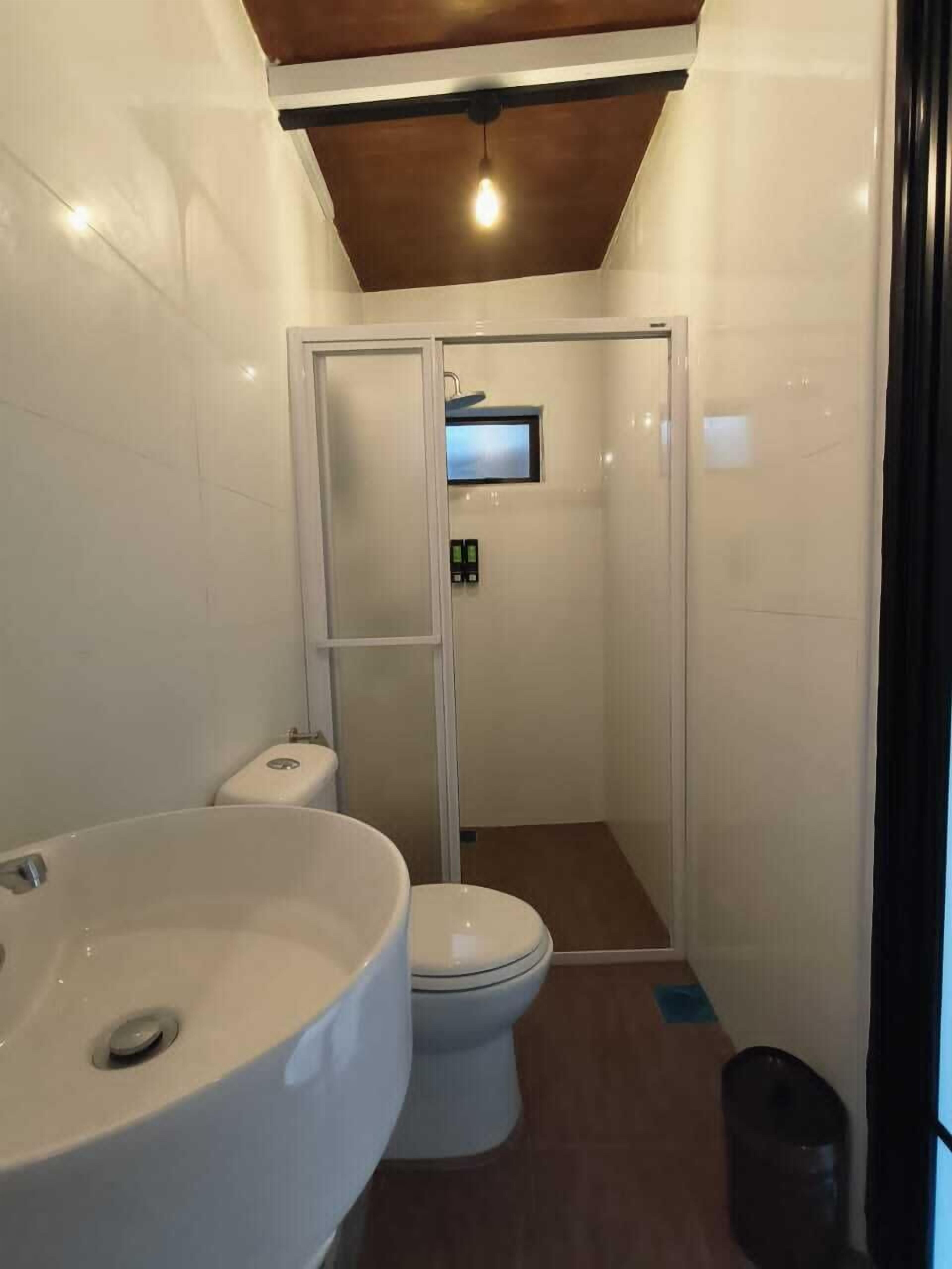 A bathroom with a large sink, toilet, and glass-enclosed shower.