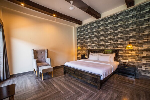 Un dormitorio con cama, una silla y una mesita de noche.