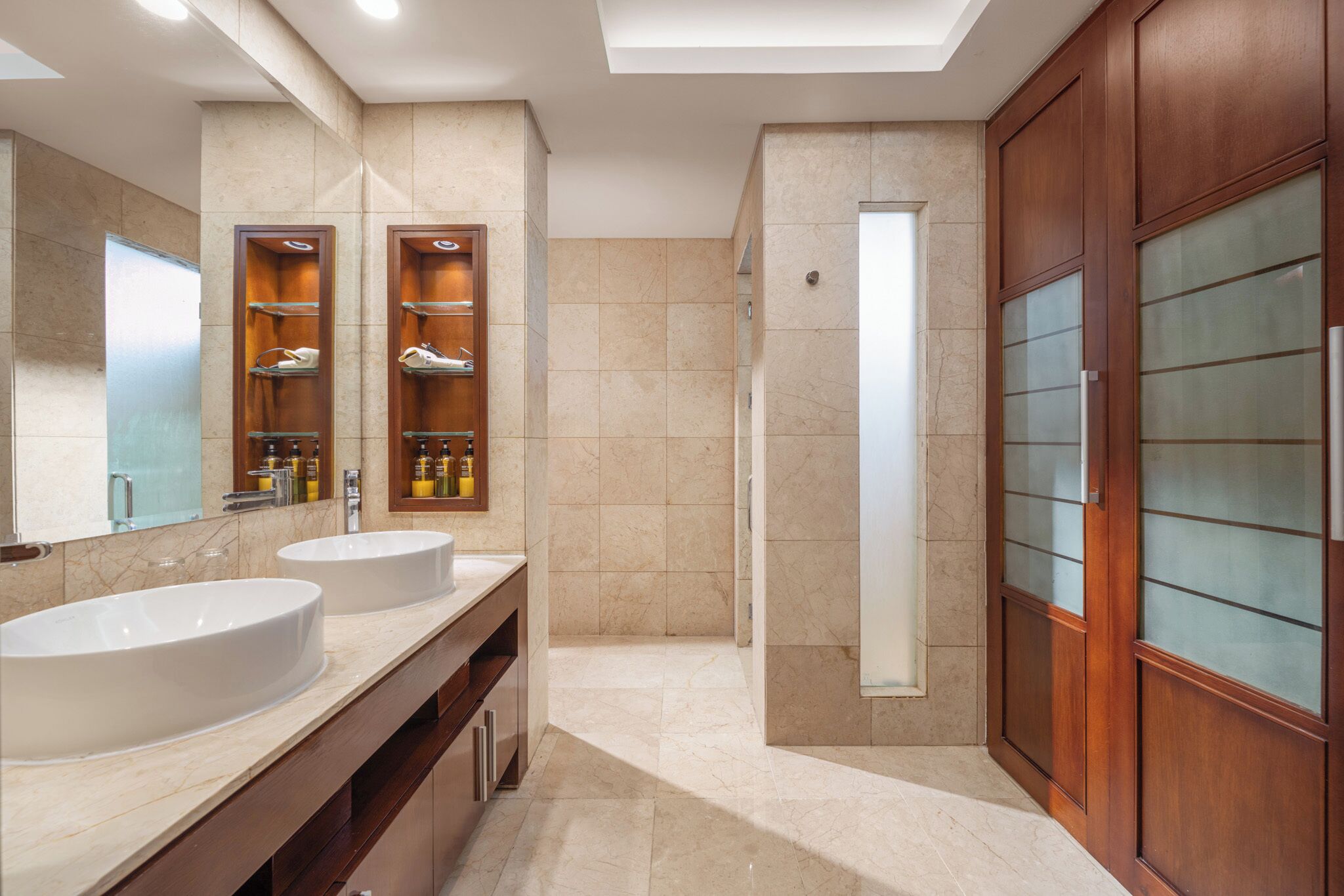Une salle de bain moderne avec deux lavabos, une douche et des meubles en bois.