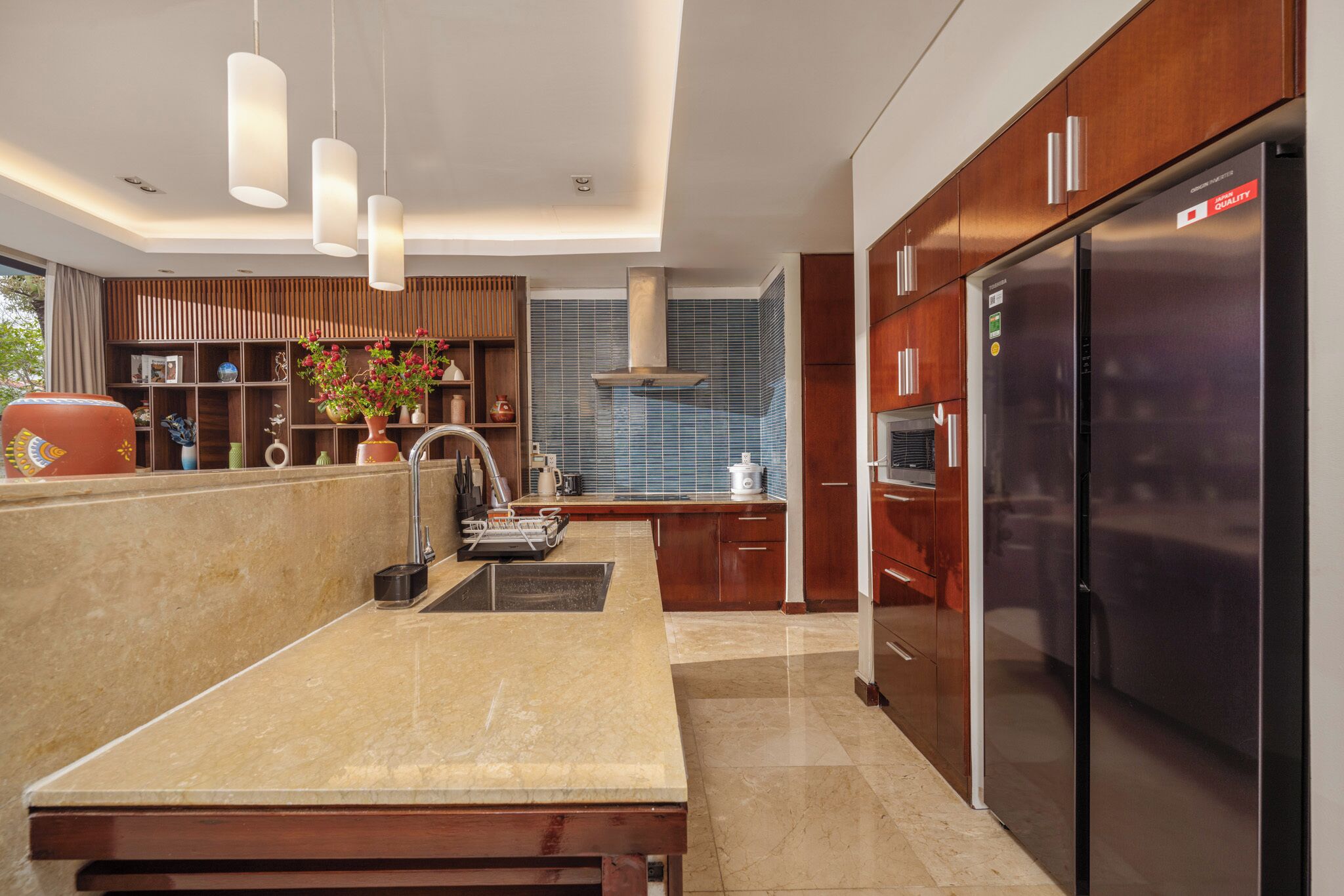 A modern kitchen with a central island, stainless steel appliances, and wooden cabinetry.