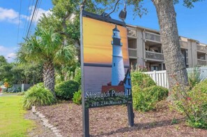 Experience the tranquility of Shipwatch Pointe II, set amidst lush landscaping and a scenic coastal backdrop.