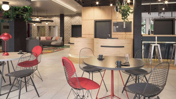 Un interior moderno con una mesa redonda, sillas metálicas y un sofá.