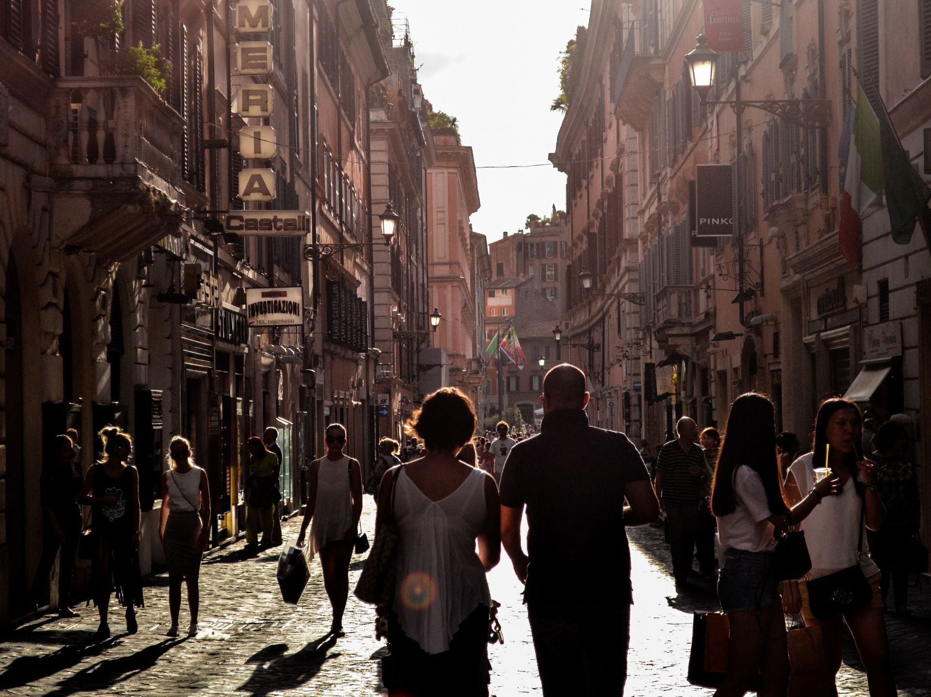 A cobblestone street lined with historic buildings, some with signage indicating local businesses.