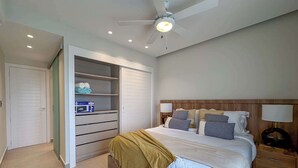 A bedroom with a bed, a wardrobe, a ceiling fan, and a nightstand. - Gorgeous new beach condo w/ PIcuzzi (Punta Cana)