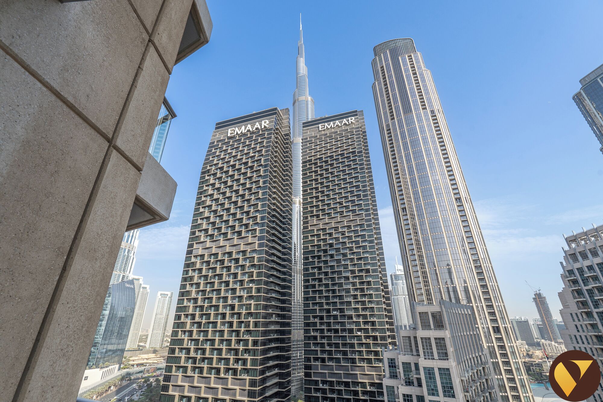 A high-rise building with a prominent spire, surrounded by other tall buildings.