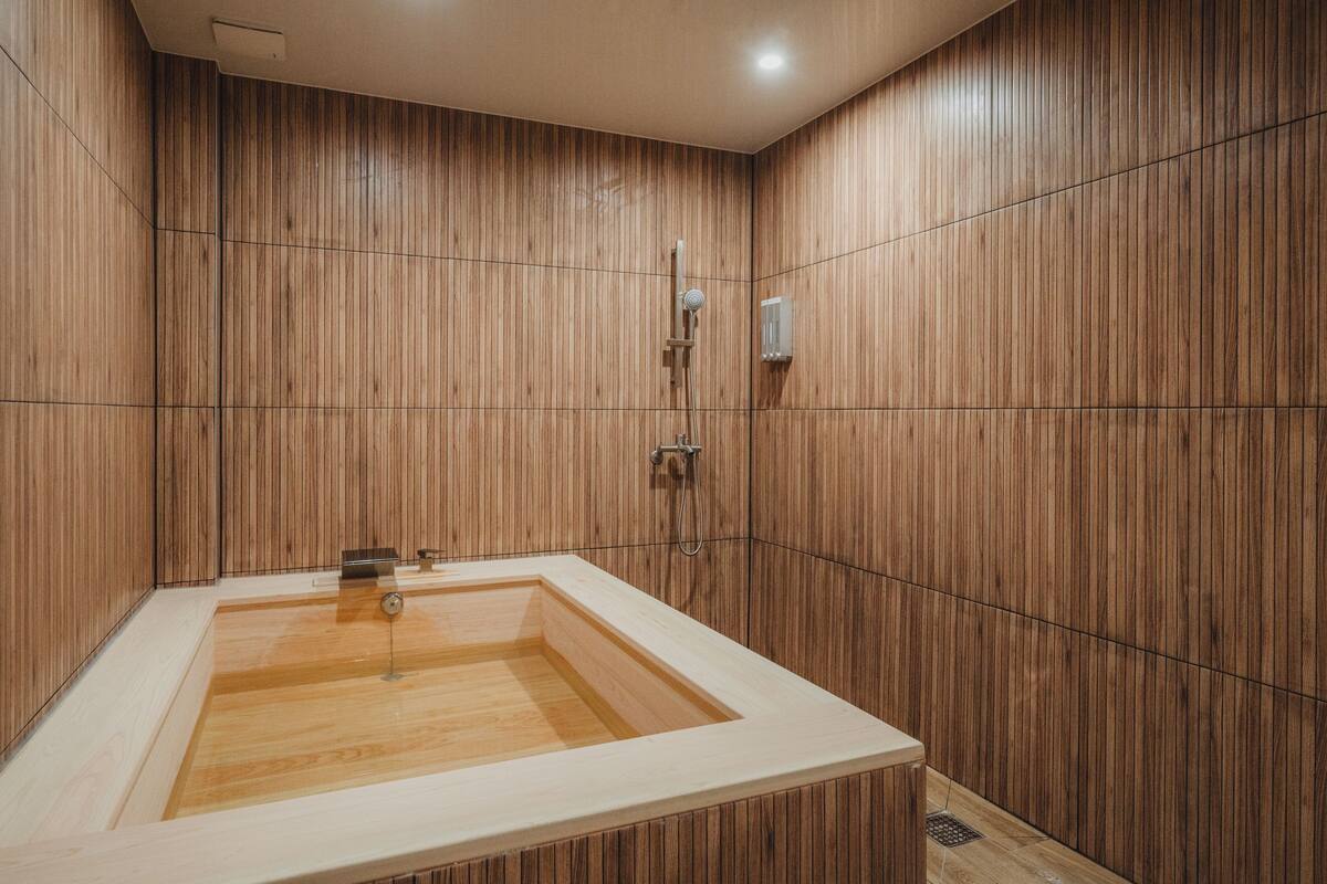Une salle de bain moderne avec un lambris en bois, une baignoire sur pieds et un espace douche.