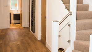 Eine Treppe mit Holzbalkon und beige farbenen Teppichstufen.