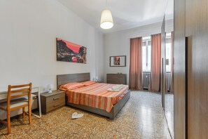 Ein Schlafzimmer mit Bett, Schreibtisch, Stuhl und Nachttisch.