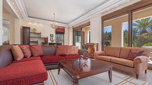 Una sala de estar moderna con un sofá seccional, una mesa de centro y un ventanal con vistas al exterior.