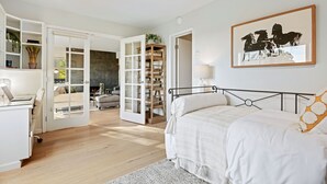 A bedroom with a bed, a desk, a chair, a bookshelf, and a fireplace. - Elegant Condo in Exclusive Polo Field Complex with Desk & Fireplace! (Carpinteria)