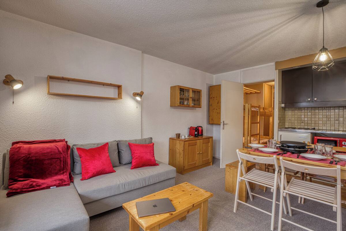 A compact living space with a sofa, a dining table, and a kitchenette.