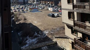 Una vista di un paese montano con edifici e un parcheggio.