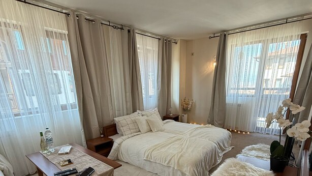 Camera d'albergo con un letto grande, un letto più piccolo, un divano, un tavolino da caffè e uno specchio.
