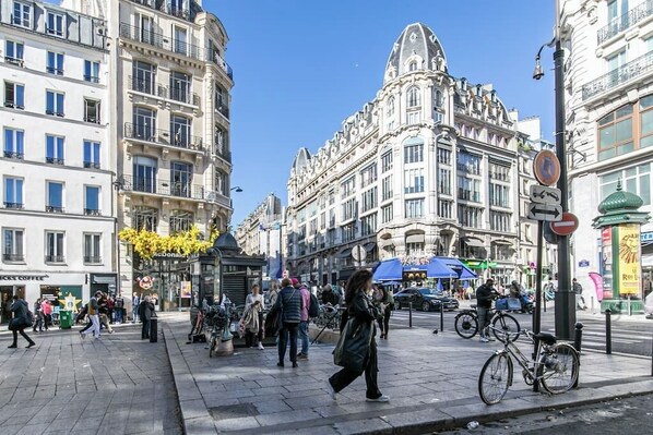 A busy urban street with pedestrians, bicycles, and classic architecture.