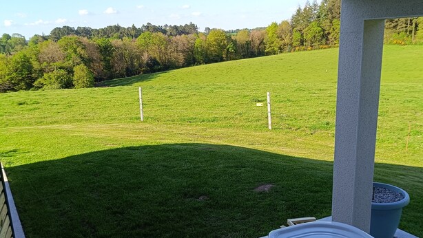 A hot tub with a view of a grassy field and trees.