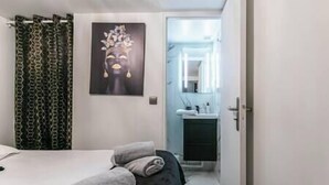 A bedroom with a bed, a bathroom with a sink and mirror, and a shower area. - Splendid 8-room apartment near Bercy (Paris)