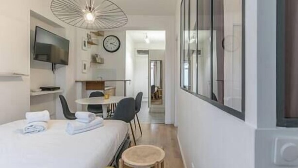 Une chambre d’hôtel avec un lit, un bureau, une chaise, une petite table, une télévision et une fenêtre.