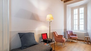 A cozy room with a sofa, two chairs, a floor lamp, and a radiator. - Guesthouse Volta38 in the center of Como! (Como)