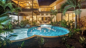 A modern house with a swimming pool, surrounded by tropical plants and a well-lit outdoor area. - Luxury Villa - 3 Mins Golf Cart to Beach - Fully Staffed (Conchal)