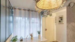 A modern interior with a dining area, a white door, and a textured wall.