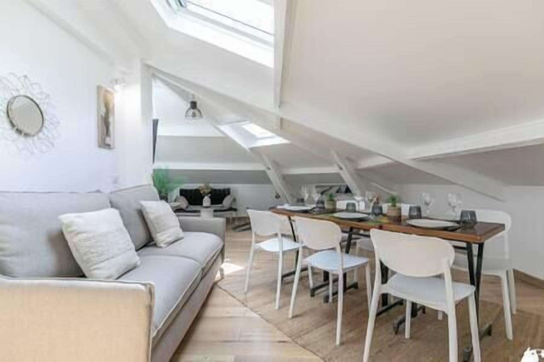 Un espace de vie de style loft comprenant un coin repas, un canapé et une table avec des chaises.