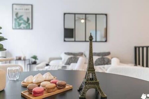 A dining table with macarons and a miniature Eiffel Tower model.