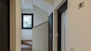 A staircase leading to a dark door with a window above it. - notaMi - Bright Attic M4 - 2 Bedrooms (Milan)