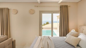 A bedroom with a bed, curtains, a view of a pool, and a balcony. - Villa Armonia - Zen Villas (Fiskardo)