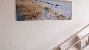A staircase leading to a room with a beach scene painting on the wall. - Room Kabine 1 (Koksijde)
