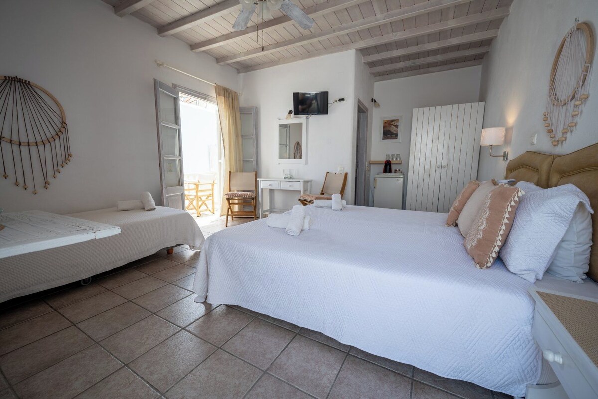 Habitación de hotel con dos camas, un escritorio, una silla, un televisor y un minibar.