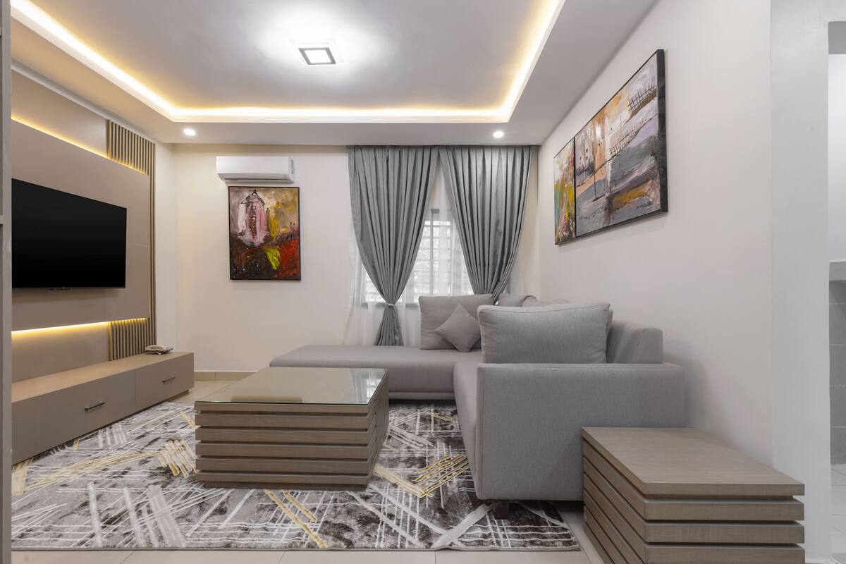 Una sala de estar moderna con un sofá, una mesa de centro y un televisor de pantalla plana.