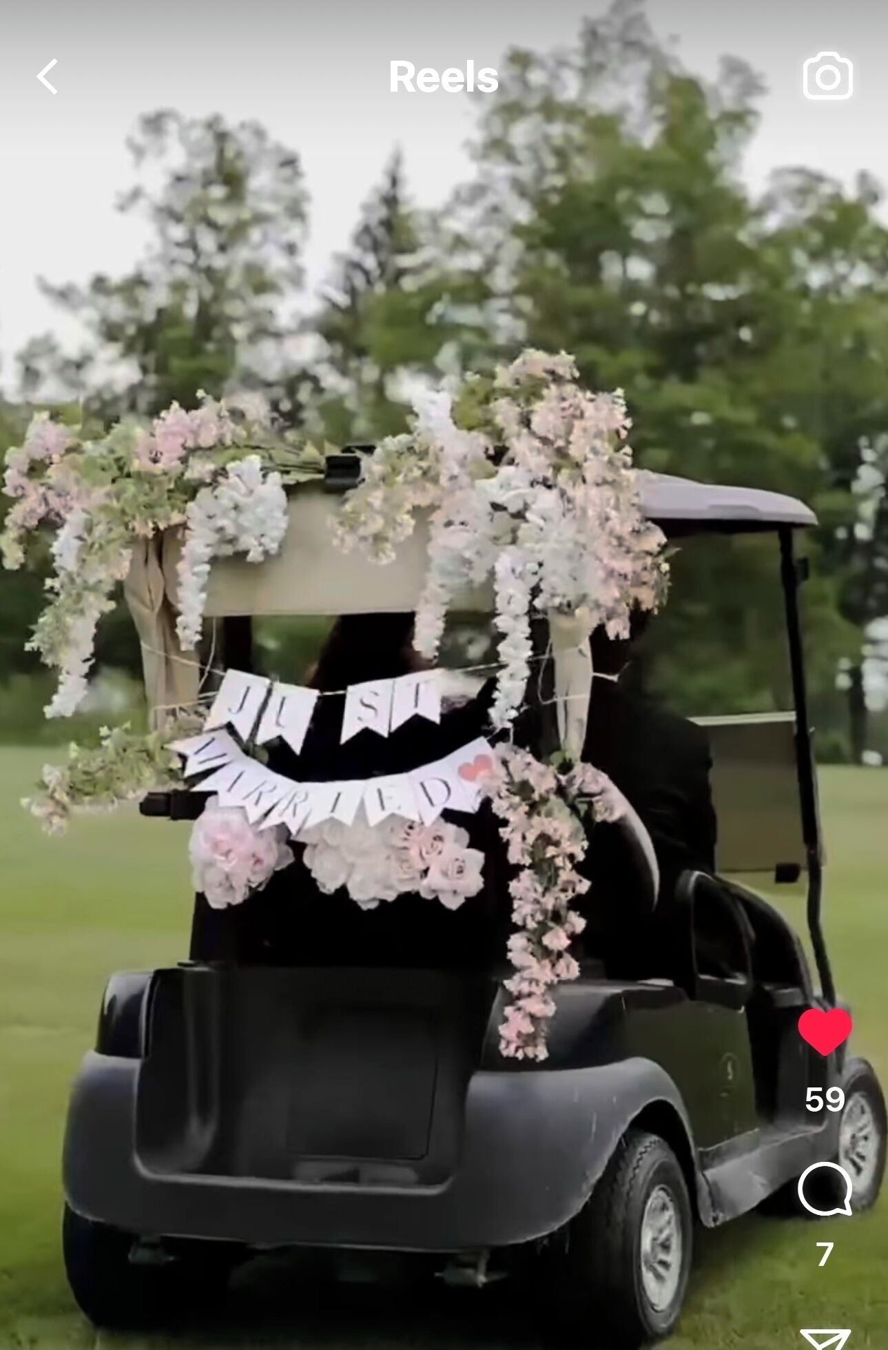 A golf cart decorated with floral arrangements and a banner.
