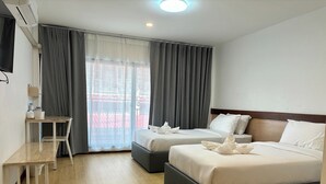A hotel room with two beds, a desk, and a large window with curtains. - M3 Bangkok Bake & Bed (Bangkok)