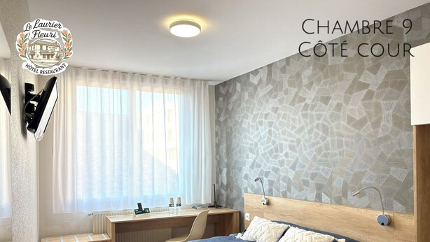 A hotel bedroom with a bed, bedside tables, a desk, and a window with curtains. - Logis Hotel Restaurant Le Laurier Fleuri (Vertou)