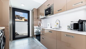 Une cuisine moderne équipée d’appareils électroménagers en acier inoxydable, d’un four encastré et d’un four à micro-ondes.