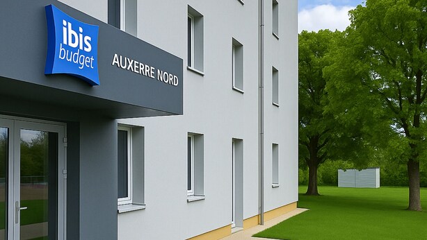 A modern building with a sign reading "ibis budget AUXERRE NORD" and a glass entrance. - Ibis Budget Auxerre Nord (Ouverture Printemps 2025) (Auxerre)