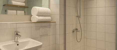 A modern bathroom with a sink, toilet, and glass-enclosed shower.