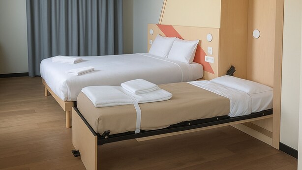 A double bed with a wooden frame, two pillows, and a blanket. - Ibis Budget Auxerre Nord (Ouverture Printemps 2025) (Auxerre)