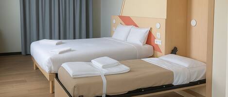 A double bed with a wooden frame, two pillows, and a blanket.