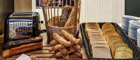 Une variété de pains et un grille-pain sur une table en bois.